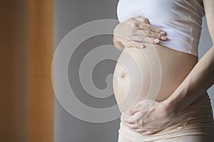 Pensive pregnant woman dreaming about child. Young happy expectant thinking about her baby and enjoying her future life