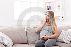 Pensive pregnant woman dreaming about child