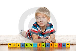Pensive preschool boy with blocks