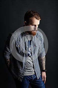 Pensive red bearded man studio portrait on dark background