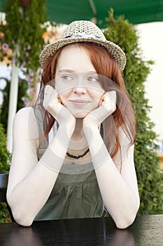 Pensive red hair woman wearing straw hat