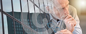 Pensive senior businessman; panoramic banner; multiple exposure