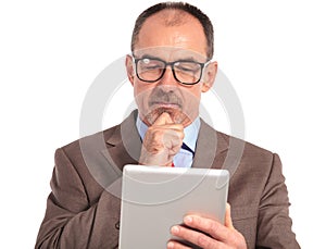 Pensive senior businessman reading on his tablet