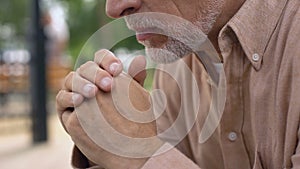 Pensive senior grandfather sitting in garden, nursing home, old age loneliness