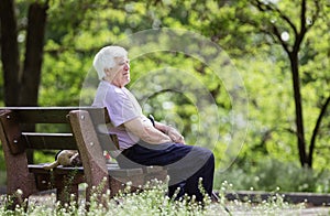 Pensive senior man sitting on bench in park