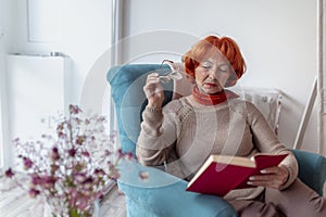 Pensive senior woman reading a book