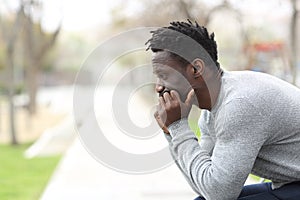 Pensive serious black man looking away on a park