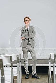 pensive smiling businessman resting chin on hand