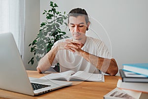 Pensive student making notes from laptop