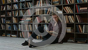 Pensive student reading a book in campus library