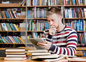 Pensive student with tablet pc at the library