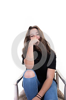 Pensive student young girl sitting on chair in white background