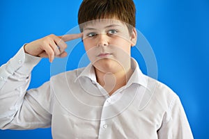 Pensive teenage boy on blue background