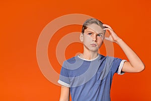 Pensive teenage boy looking up with thoughtful expression