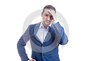 Pensive and upset businessman keeps hand to head looking stressed and bewildered isolated on white background. Man suffering