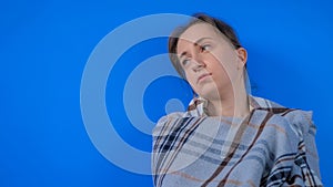 Pensive woman feeling sick, looking away against blue background at home