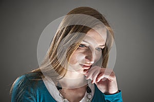 Pensive woman on gray background