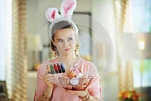 Pensive woman holding basket with eggs and reading instruction