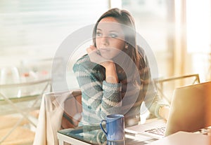 Pensive woman with laptop