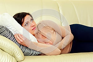 Pensive woman lying on the sofa