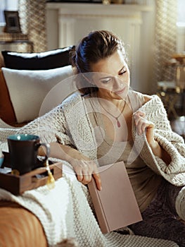 Pensive woman in modern living room in sunny autumn day