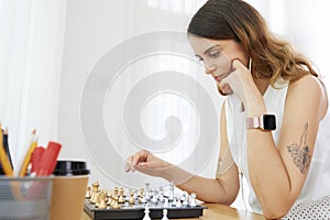 Pensive woman playing chess