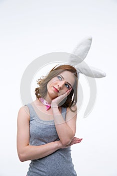 Pensive woman in rabbit ears looking up