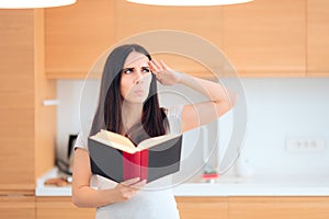 Pensive Woman Reading a Book in The Kitchen