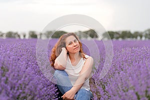 Pensive woman sitting in a lavender field