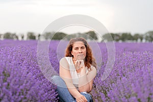 Pensive woman sitting in a lavender field