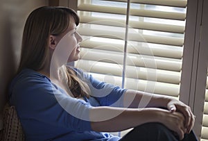 Pensive Woman Sitting Near Window Shades