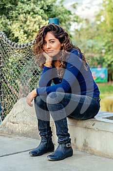 Pensive woman sitting outdoors on concrete step