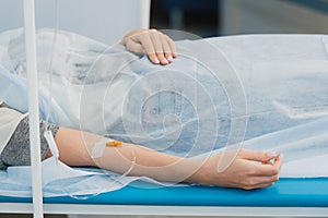 Pensive woman transfused lying in hospital ward