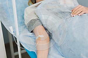 Pensive woman transfused lying in hospital ward