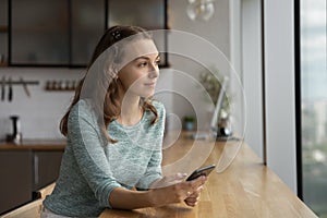 Pensive woman use cellphone thinking or making plans