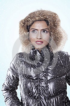 Pensive woman wearing winter jacket on studio