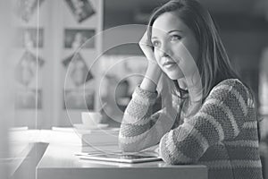 Pensive woman at window