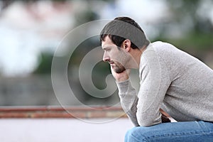 Pensive worried man sitting on a bench