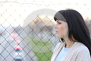 Pensive worried woman looking away on a bridge