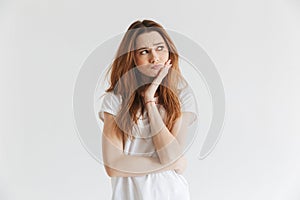 Pensive worried woman in t-shirt touching her cheek