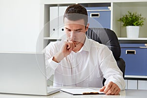 Pensive young businessman with notebook