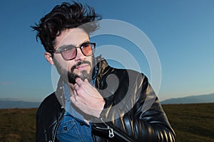 Pensive young fashion man with beard and glassess