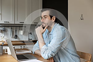 Pensive young male student pondering on task on distance learning