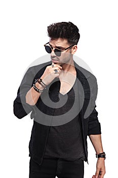 Pensive young man in black clothes looks to side