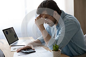 Pensive young man calculate household expenses thinking