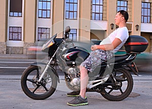 Pensive young man with motorcycle