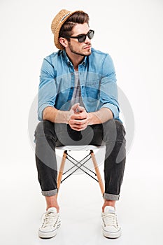 Pensive young man sitting on chair and thinking