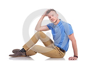 Pensive young man sitting on the floor