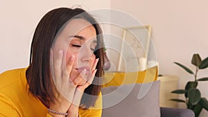 Pensive young pretty woman feeling worried with thinking on sofa at home