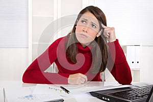 Pensive young trainee at desk - unhappy and bored. photo